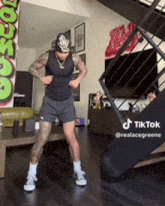 a man is dancing in a living room with stairs in the background and a sign that says tik tok