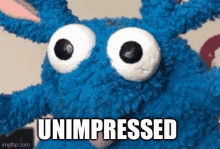 a blue stuffed animal with big eyes and the word unimpressed written on it