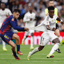 a soccer player with the number 7 on his jersey is trying to pull another player 's shirt off