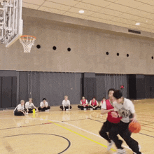 a group of people are playing basketball on a court with a scoreboard in the background that shows a score of 10 to 0