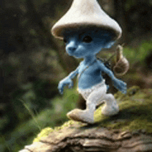 a smurf wearing a mushroom hat and carrying a snail on his back is walking on a rock .