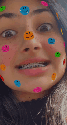 a girl with braces on her teeth has many smiley faces on her face