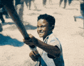 a young boy is holding a wooden stick in his hands