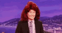 a woman with red hair in a suit and tie