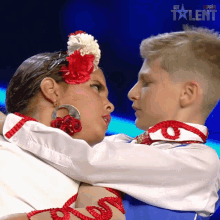 a boy and a girl are hugging each other in front of a screen that says got talent on it