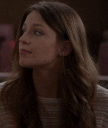 a close up of a woman 's face with long hair and earrings