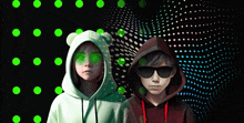 a boy and a girl wearing hoodies and sunglasses are standing next to each other