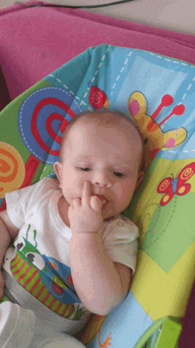 a baby is sitting in a bouncer and making a face