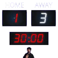a man stands in front of a scoreboard that reads home 1 away 3