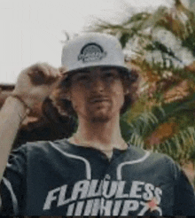 a man wearing a baseball cap and a shirt that says flawless hips .