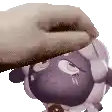 a person is petting a purple sheep with a sponge .