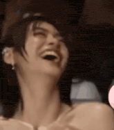 a woman is laughing with her mouth open in a close up of her face .
