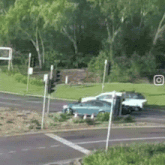 a blue car and a white car are driving down a street