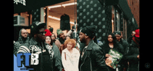 a group of people are standing in front of a store with the letters fb on the bottom
