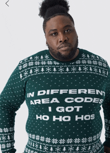 a man is wearing a green sweater that says in different area codes i got ho ho ho