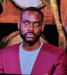 a man with a beard is wearing a red jacket and white shirt