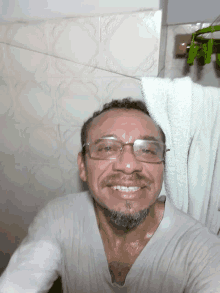 a man with glasses and a towel on his head smiles