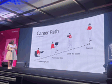 a woman stands in front of a large screen that says career path on it