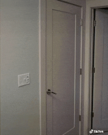 a white door with a light switch on the wall