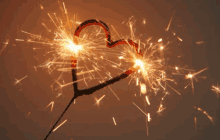 sparklers in the shape of a heart are lit up in the dark