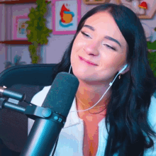 a woman wearing headphones is smiling in front of a microphone with a picture of a fire on the wall behind her