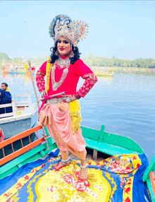 a woman in a costume is standing on a boat near the water