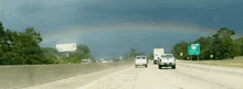 a highway with a rainbow in the sky and a sign that says ' i - 95 '