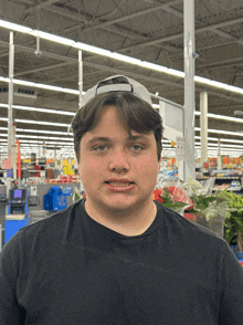 a young man wearing a hat and a black shirt is standing in a store