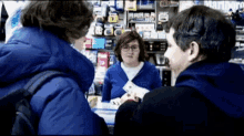 a man in a blue jacket is talking to a woman in a store that says marlboro on the wall