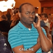 a man in a blue shirt is talking on a cell phone and says call me .