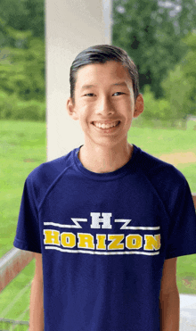 a boy wearing a blue shirt that says horizon on it