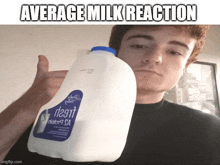 a man holding a gallon of milk with average milk reaction written on it