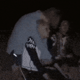 a man wearing a shirt that says discover on the sleeves is hugging another man