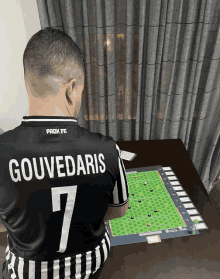 a man wearing a black and white jersey with the name gouvedaris on it