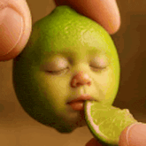a person is holding a lime with a face on it