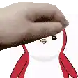 a hand is holding a penguin 's head with a red ribbon around its neck .