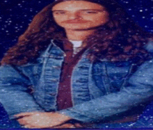 a man with long hair and a denim jacket