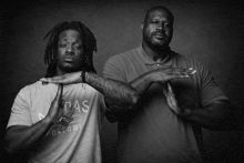 a man in an adidas shirt stands next to another man