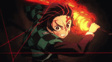 a young boy is holding a torch in his hand in a demon slayer anime .