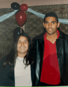 a man and a woman are posing for a picture in front of balloons