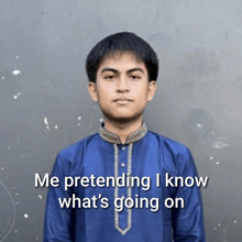 a young man in a blue shirt is pretending he knows what 's going on behind him