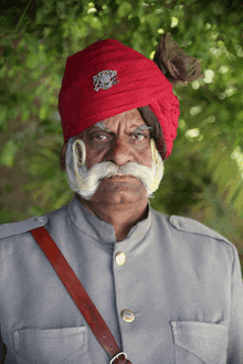 a man wearing a red turban has a badge on his hat that says ' army ' on it