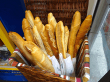 a bunch of bread sticks in a basket that says ' oficina ' on the bag