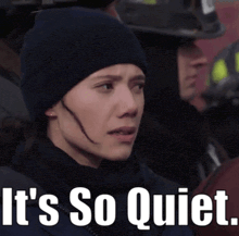 a woman wearing a hat and scarf with the words it 's so quiet written below her