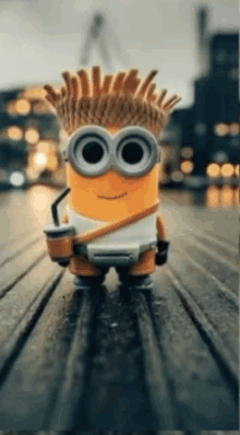 a minion with french fries on his head holds a drink