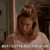 a woman in a bra is standing in a closet .