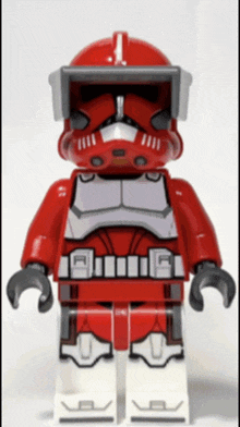 a red lego clone trooper with the number 1 on his helmet stands on a white surface