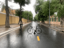 a person riding a bike on a wet road with a bicycle that says ' lgc ' on the front