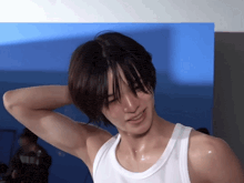 a man wearing a white tank top has sweat coming out of his armpits