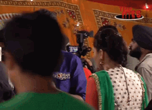 a woman in a green and white polka dot dress stands in front of a sign that says team india